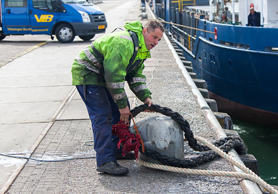 Bootman met tros rond een bolder